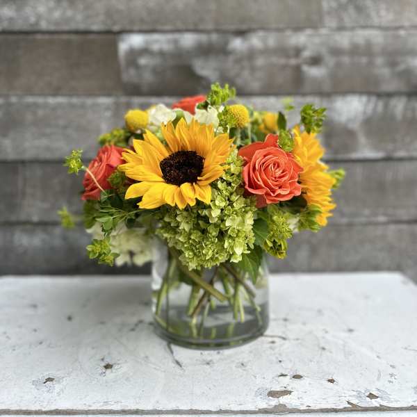 Sunflower and rose bouquet in a clear glass vase