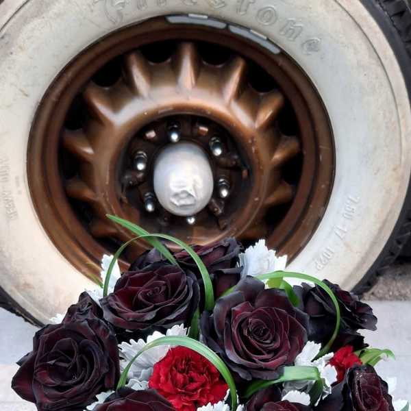 Bouquet of dark red roses and red carnations in a silver vase