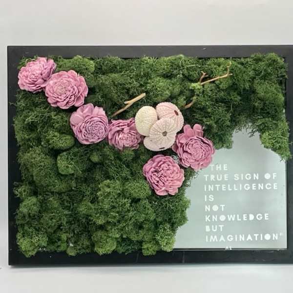 Framed moss wall with pink flowers and a quote panel