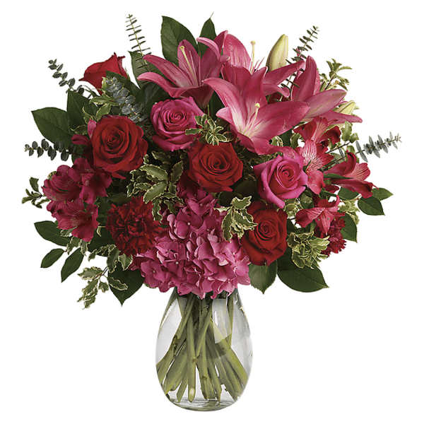 Bouquet of pink lilies and red roses in a clear glass vase