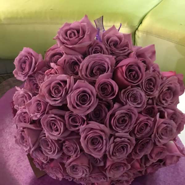 Bouquet of purple roses wrapped in purple paper