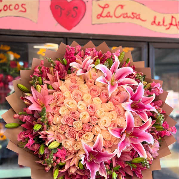 Large bouquet of pink roses and lilies wrapped in brown paper