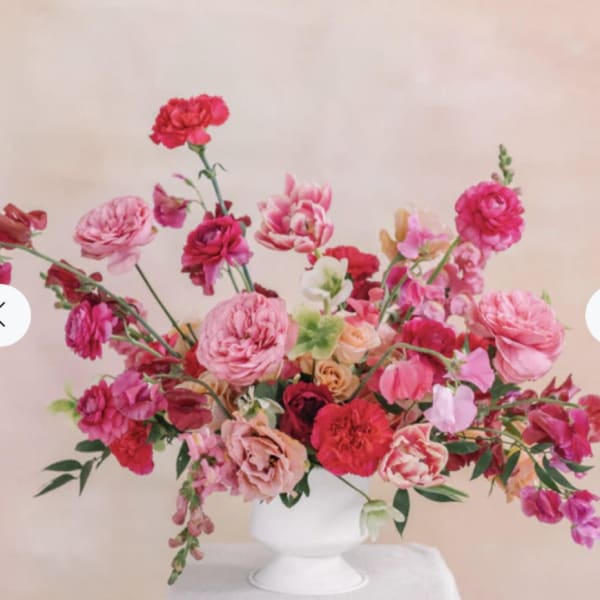Pink and red mixed flower arrangement in a white vase