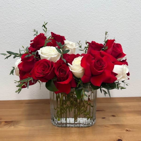 Red and white roses arranged in a clear glass vase