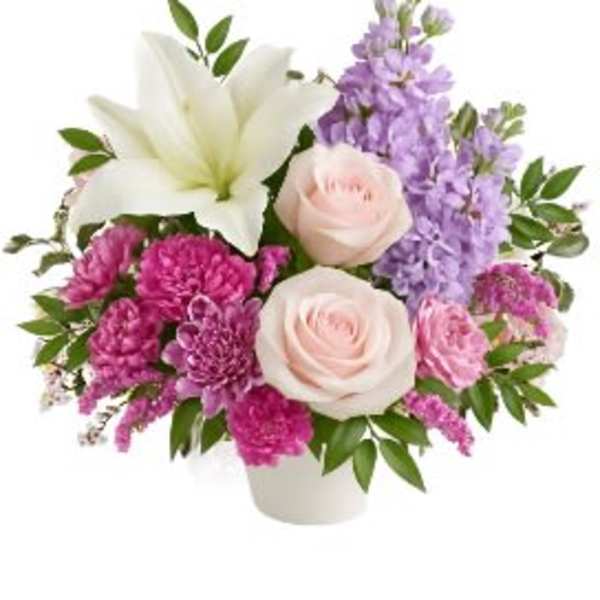 Pink and lavender bouquet with white lilies and roses in a white vase
