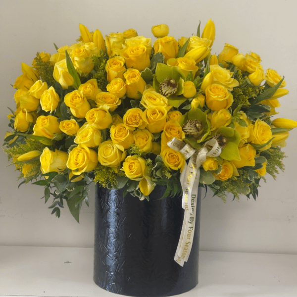 Yellow roses and tulips arranged in a black vase