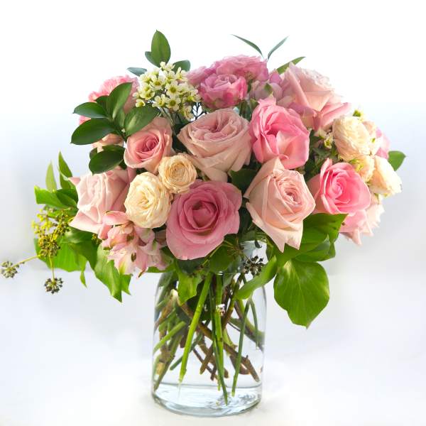 Pink and cream roses arranged in a clear glass vase