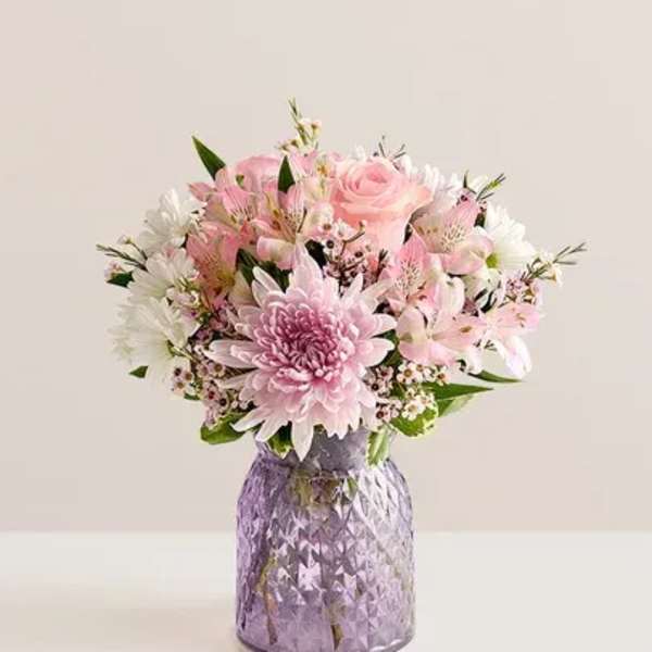 Pink and white mixed bouquet in a purple glass vase
