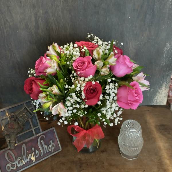 Pink and red roses with white baby's breath in a glass vase