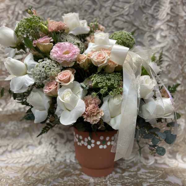 Bouquet of white and blush flowers in a decorated terracotta pot