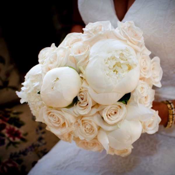 Bride holding a white bouquet of roses and peonies