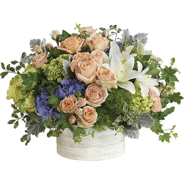 Peach roses and white lilies in a low white container