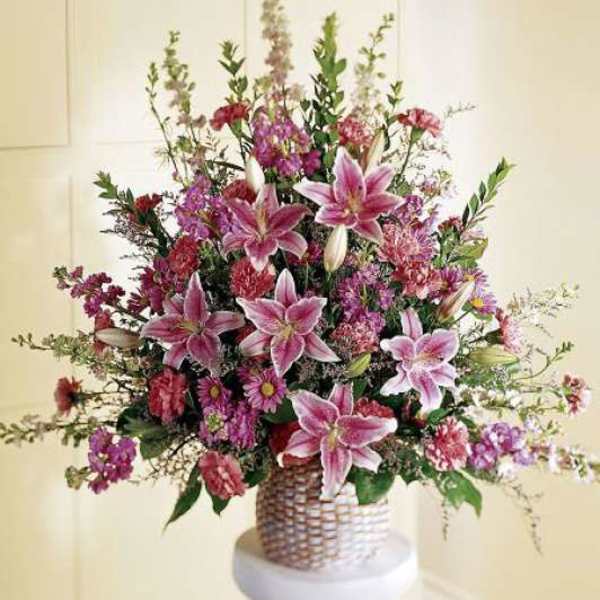 Large bouquet of pink lilies and mixed flowers in a woven basket