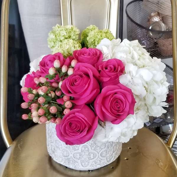 Pink roses and white hydrangeas in a white decorative box