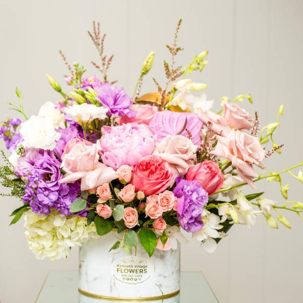 Mixed pink, purple, and white bouquet in a white vase