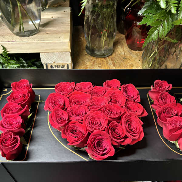 Red roses arranged in a black presentation box