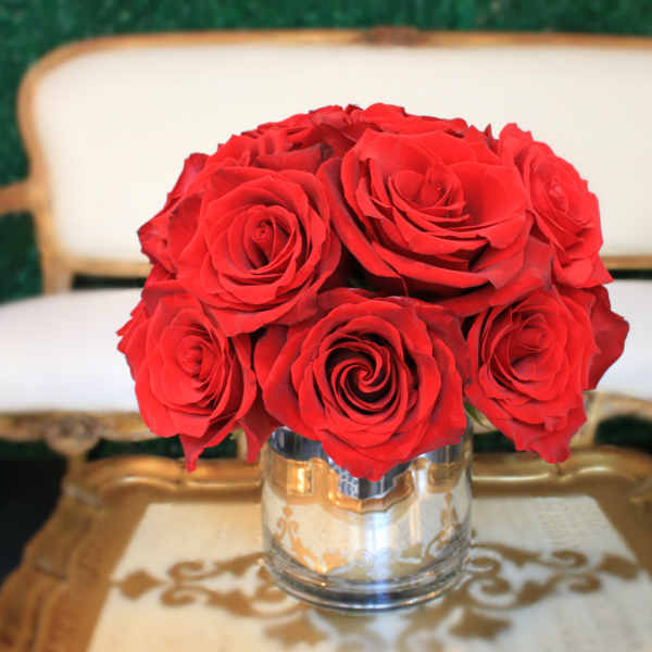 Red roses arranged in a clear glass vase