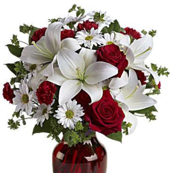 Red roses and white lilies in a red glass vase