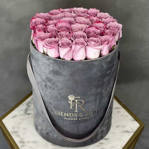 Pink roses arranged in a gray round hat box