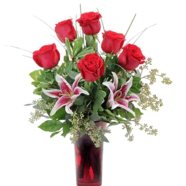 Red roses and pink lilies in a red glass vase