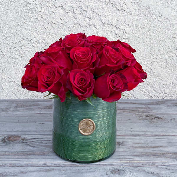 Red roses arranged in a green cylindrical vase