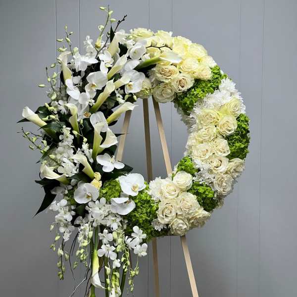 Large white floral wreath on a wooden easel