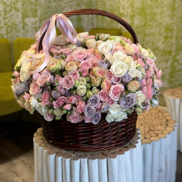 Basket of pastel roses with a pink ribbon bow