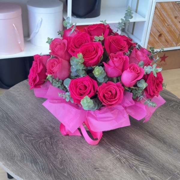 Bouquet of hot pink roses with eucalyptus and pink wrapping