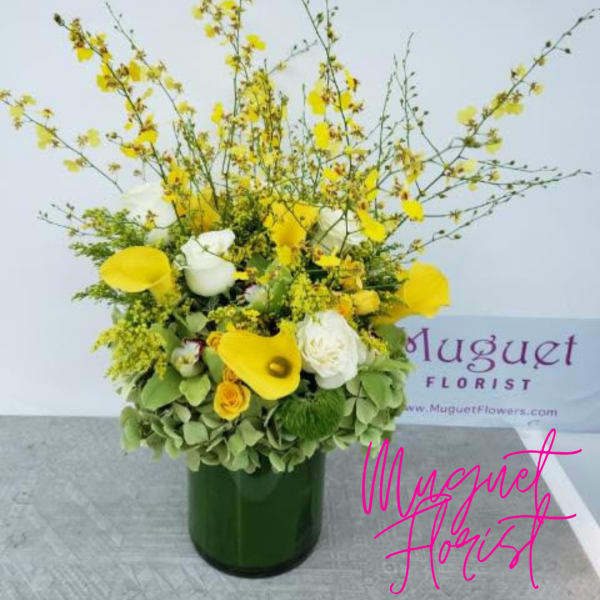 Yellow and white floral arrangement in a green vase