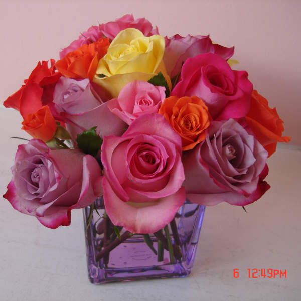 Mixed roses in a purple glass vase