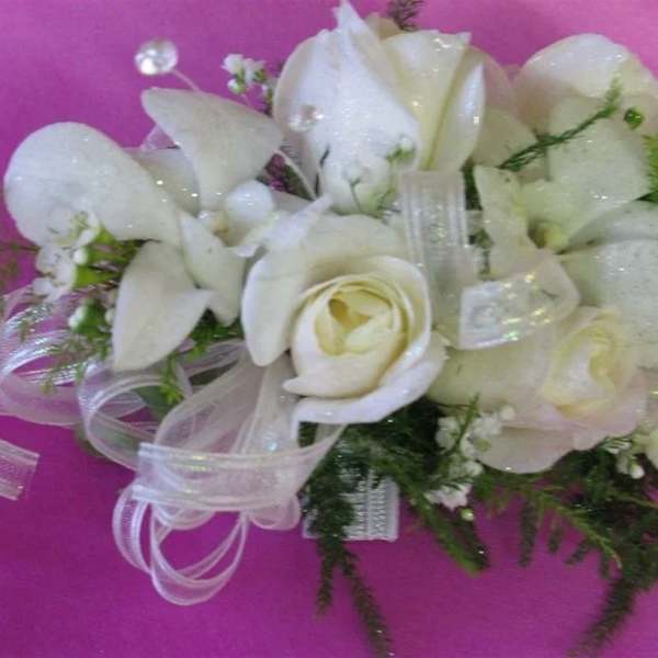 White rose and orchid bouquet with sheer ribbon on pink background