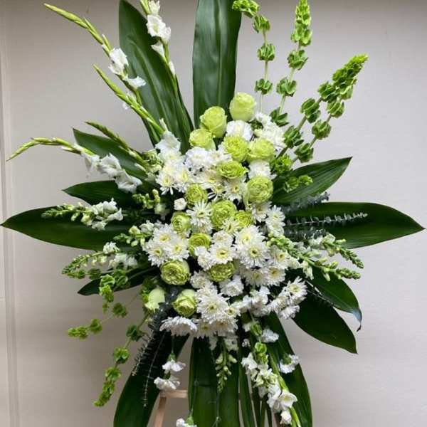 Tall white and green floral standing arrangement on an easel