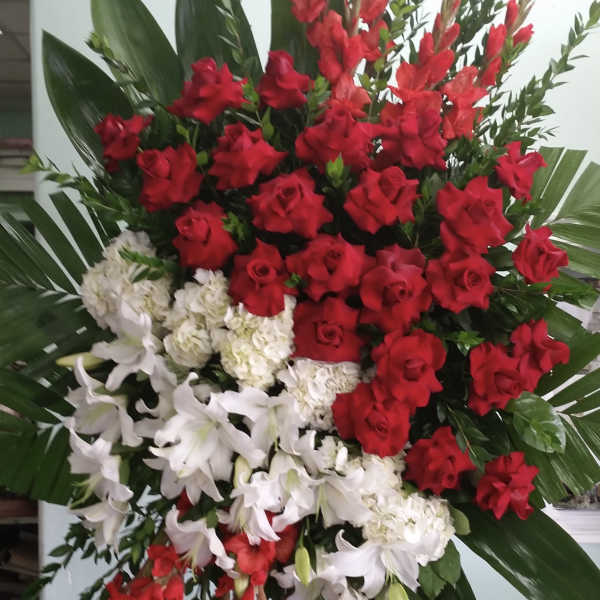 Large standing floral spray with red roses and white lilies