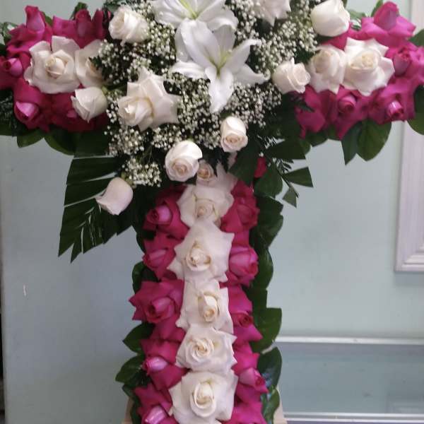 Cross-shaped floral arrangement with pink and white roses and white lilies