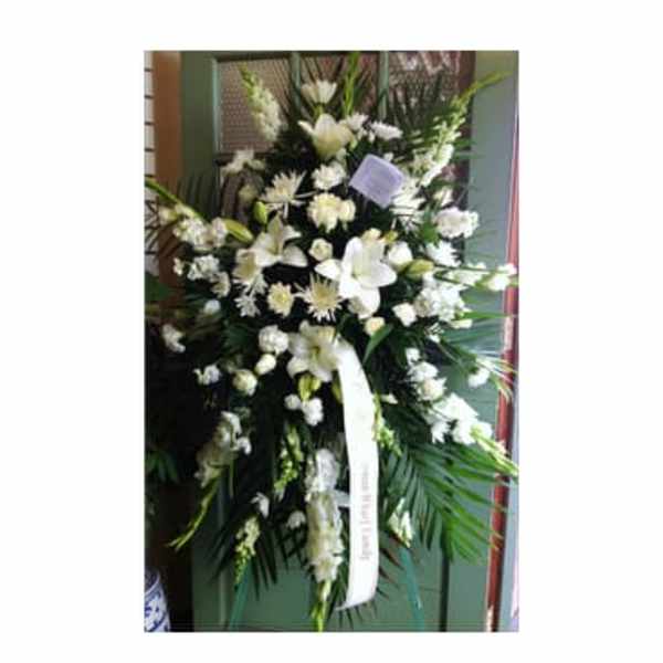 Tall white floral standing spray with a ribbon