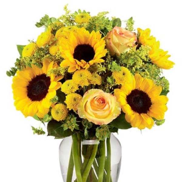 Sunflowers and peach roses arranged in a clear glass vase