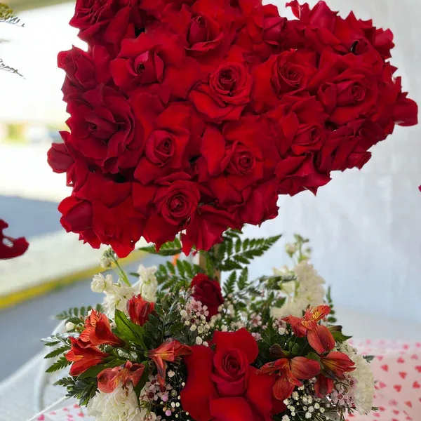 Heart-shaped red rose arrangement above a mixed red and white floral bouquet