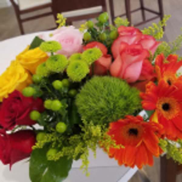Bright mixed bouquet with orange gerbera daisies, multicolored roses, and green button mums