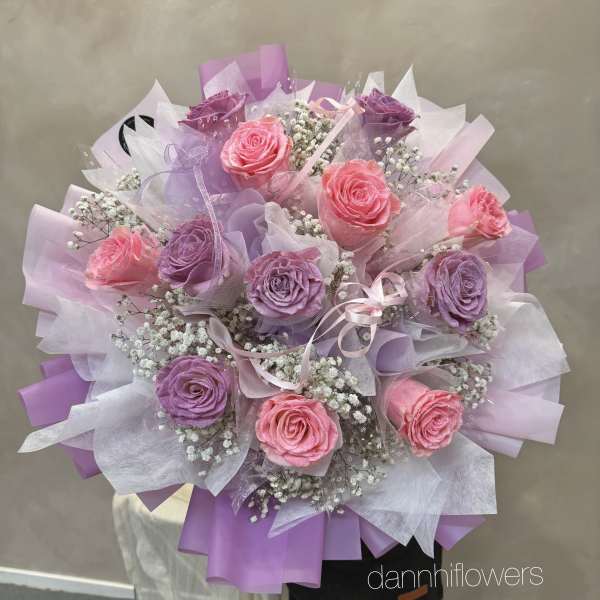 Bouquet of pink and purple roses wrapped in lavender paper