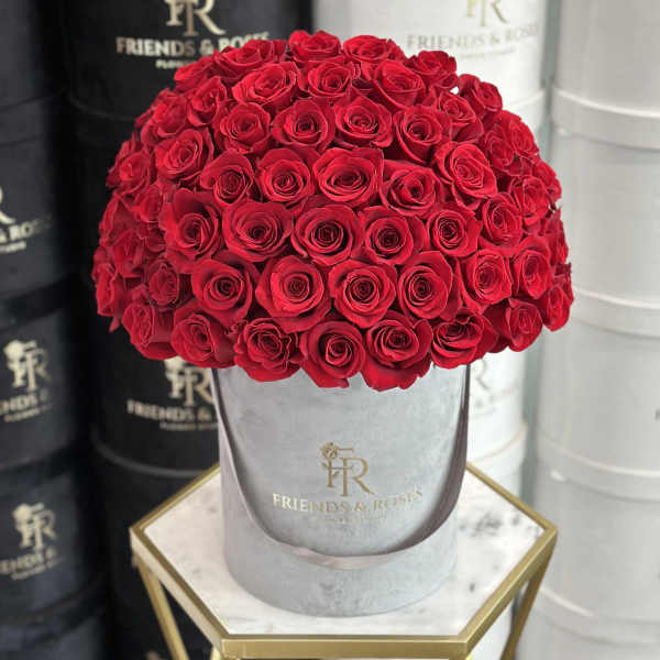 Large bouquet of red roses in a gray hatbox