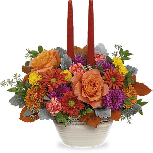 Fall floral centerpiece with two red taper candles in a white bowl