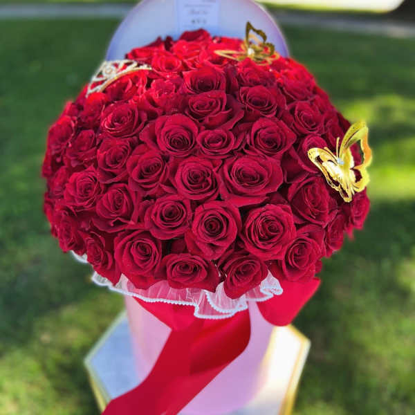 Round bouquet of red roses with butterfly accents and a red ribbon