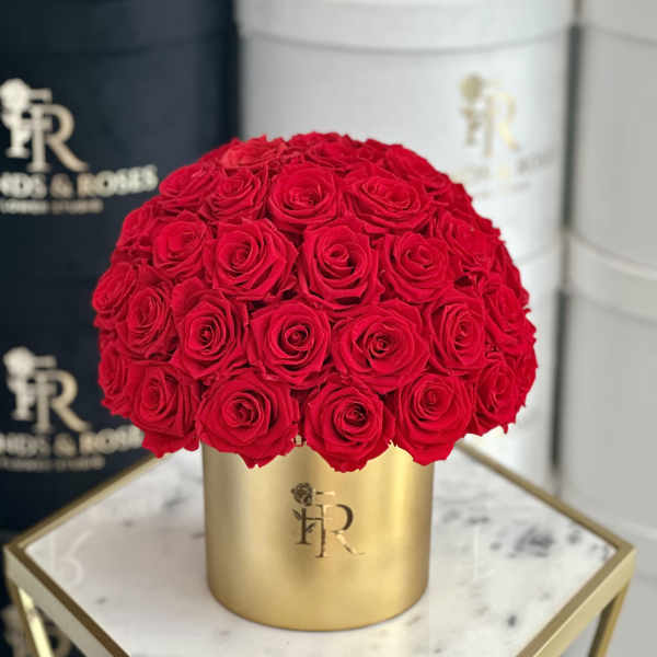Round bouquet of red roses in a gold box