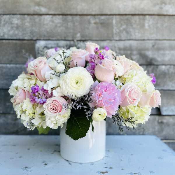 Pink and white flower arrangement in a white vase