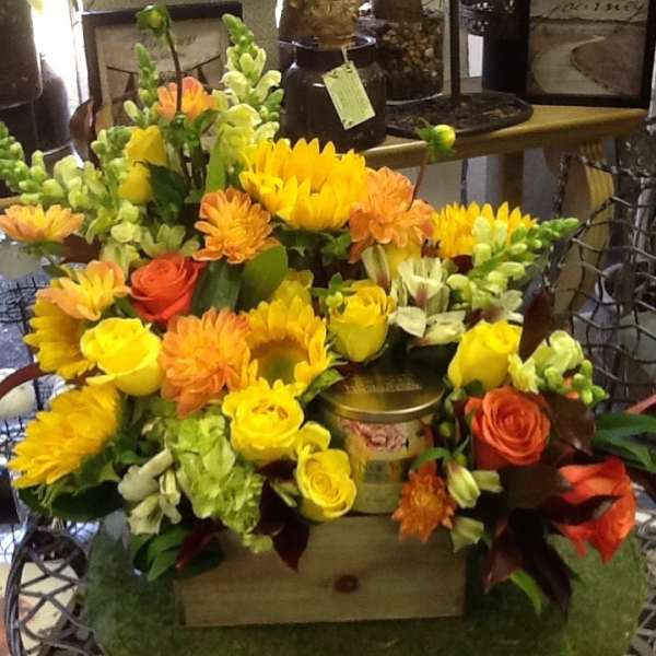 Mixed bouquet of yellow and orange flowers with roses in a wooden box