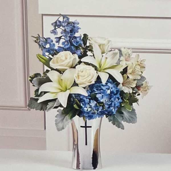 White lilies and roses with blue hydrangeas in a silver vase