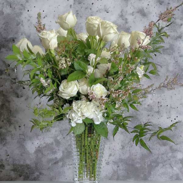 White roses and hydrangea in a clear glass vase