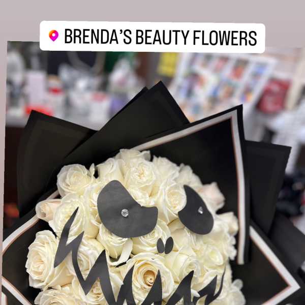 Bouquet of white roses wrapped in black paper with a black ribbon