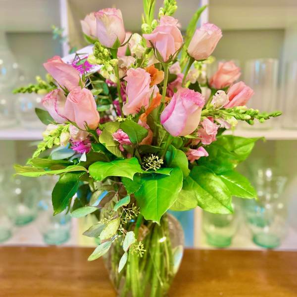 Pink roses and snapdragons in a clear glass vase