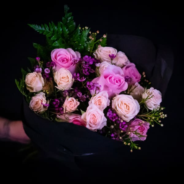 Bouquet of pink and cream roses with purple filler flowers